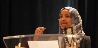 Woman in hijab speaking at a podium