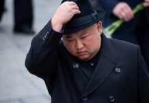 North Korea Sends A Message With Missiles man in black coat adjusting a black hat