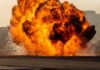 Fireball explosion with thick smoke on an open ground