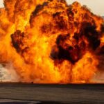 Fireball explosion with thick smoke on an open ground