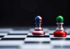 Two chess pawns with U.S. and Iran flag designs on a board