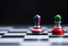 Two chess pawns with U.S. and Iran flag designs on a board