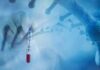 Gloved hand holding a COVID-19 test tube beside a stylized DNA helix