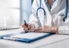 Doctor writing on a clipboard with stethoscope