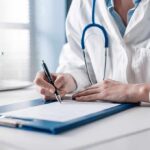 Doctor writing on a clipboard with stethoscope