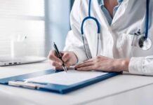Doctor writing on a clipboard with stethoscope