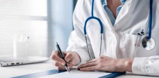 Doctor writing on a clipboard with stethoscope