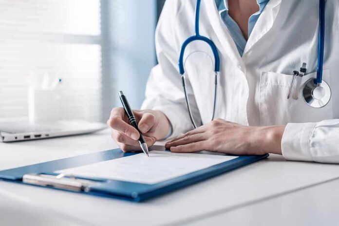 Doctor writing on a clipboard with stethoscope