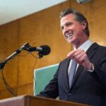 Speaker in a suit addressing an audience at a podium