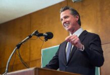 Speaker in a suit addressing an audience at a podium
