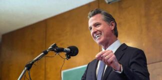 Speaker in a suit addressing an audience at a podium