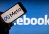 Smartphone showing Meta logo against blurred Facebook background