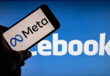 Smartphone showing Meta logo against blurred Facebook background