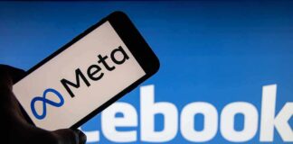 Smartphone showing Meta logo against blurred Facebook background