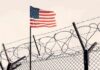 American flag above barbed wire fence