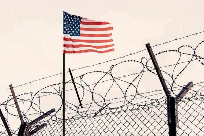 American flag above barbed wire fence