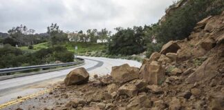 Rockslide blocking a curved mountain road