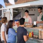 food truck staff serve drinks to customers at window