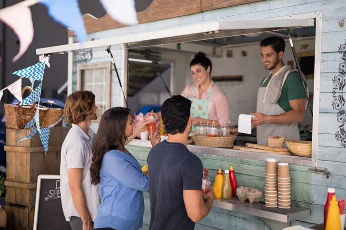 food truck staff serve drinks to customers at window