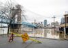 Flooded riverfront with bridge and city skyline