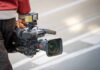 camera operator carrying a professional video camera