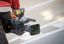 Three Outlets Banned From White House camera operator carrying a professional video camera