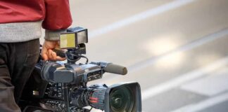 camera operator carrying a professional video camera