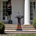 Trump 2028 Hat Triggers Constitutional Jitters Podium with presidential seal in a garden colonnade