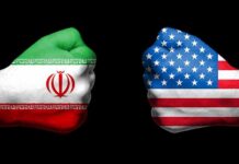 Fists painted as Iran and United States flags facing each other