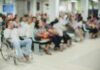 Crowd of people waiting in a hospital waiting area