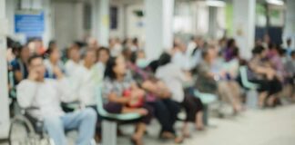 Crowd of people waiting in a hospital waiting area