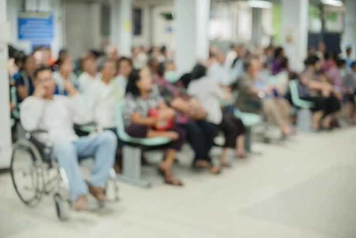 Crowd of people waiting in a hospital waiting area