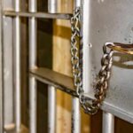 Prison cell door with key and chain in lock