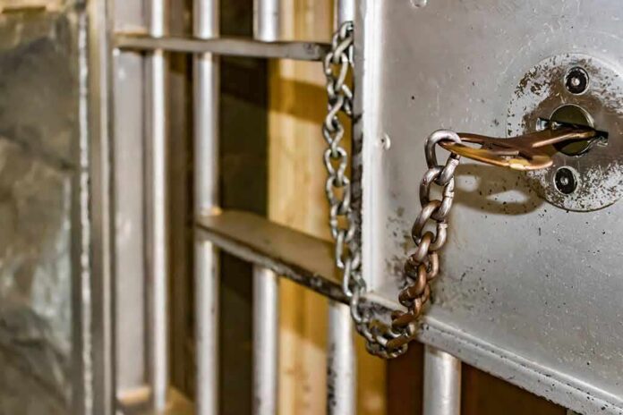 Prison cell door with key and chain in lock