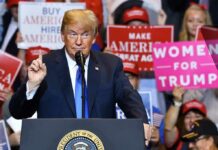 politician speaking at rally podium