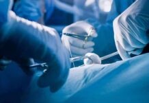 Surgeons' gloved hands performing an operation