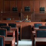 Public Execution Push After Mistrial Empty courtroom with wooden benches and judge's bench