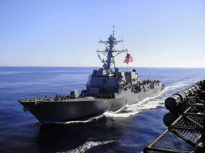 shutterstock_1250591794 naval destroyer sailing at sea with flag flying