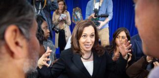 Kamala Harris speaks to a crowd as Maya Harris stands nearby