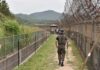 Mysterious Blast Injures Troops Soldier walking along a fenced border path
