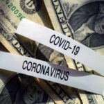 U.S. dollar bills with labels reading COVID-19 and coronavirus