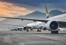Commercial airliners lined up on an airport taxiway at dusk