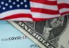 American flag over a dollar bill and a COVID-19 relief check