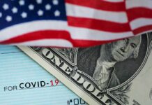 American flag over a dollar bill and a COVID-19 relief check