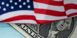 American flag over a dollar bill and a COVID-19 relief check