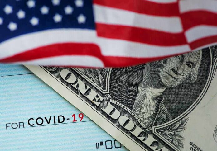 shutterstock_1691814493 American flag over a dollar bill and a COVID-19 relief check
