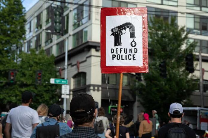shutterstock_1754701871 Protesters holding a red sign in a city street