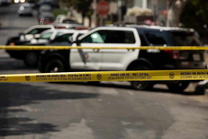 shutterstock_1980603047 Police tape cordoning off street with patrol SUVs behind