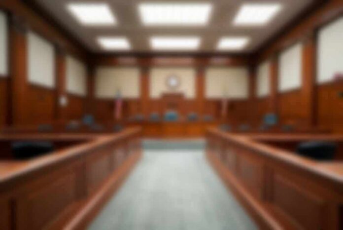 shutterstock_2324977165-3 Empty courtroom with wooden benches and judge's bench