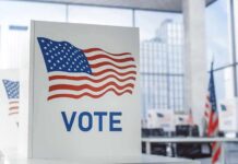 Cheating Charge Explodes – Harris vs. GOP Voting booth with American flag design in a modern polling place